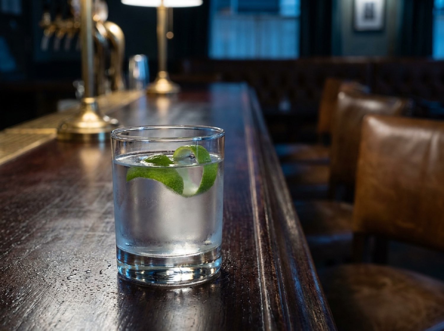 Sterling Crest detail — single cocktail on dark bar top, green citrus