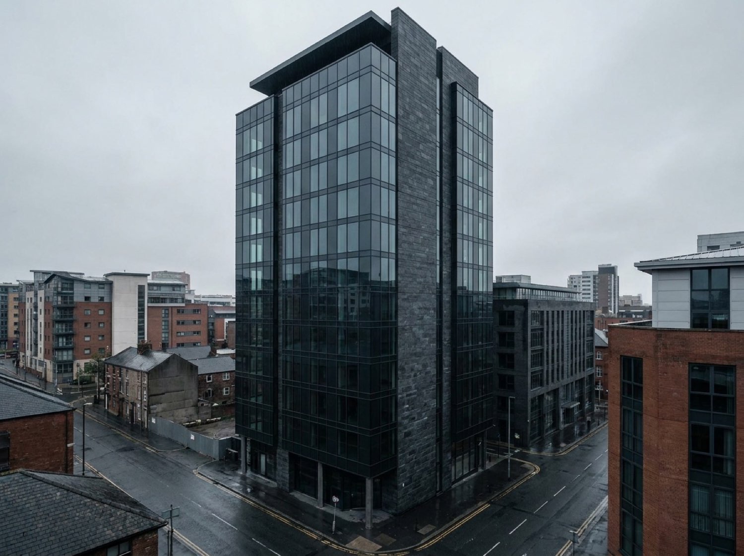 Sterling Crest exterior by day — dark glass and stone tower, overcast Leeds sky
